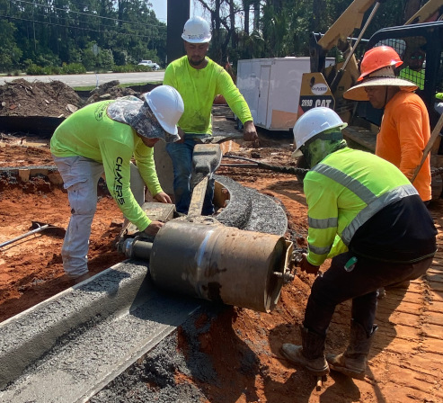 a worker smoothing a concrete curb