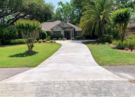 a long concrete driveway leading to a house