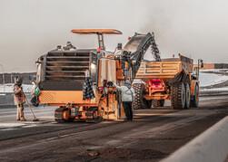 milling machine dumping old pavement in a dump truck