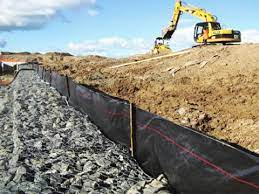 a silt fence on the job site separating rocks on one side and dirt on the other